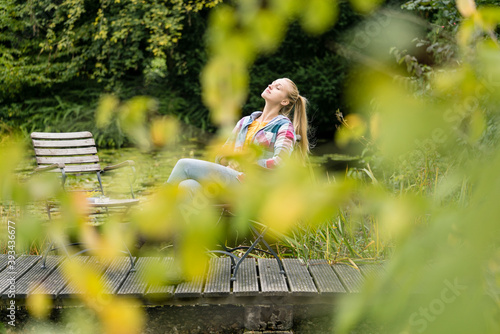 Young woman relaxing on jetty in garden