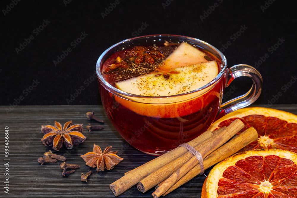 Mulled Wine for Christmas and winter holidays. Hot drink with fruits and spices on dark background. Mulled Wine for Christmas and winter holidays. Hot drink with fruits and spices on dark background.