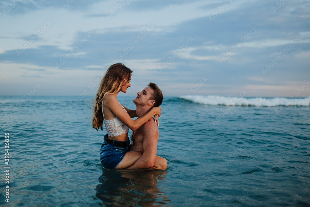 Boyfriend carrying girlfriend while standing in water at beach Boyfriend carrying girlfriend while standing in water at beach