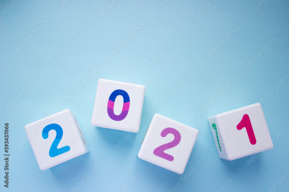 Cubes with colorful numbers 2021 at the bottom of the photo on blue background. New year, calendar. With place for text Cubes with colorful numbers 2021 at the bottom of the photo on blue background. New year, calendar. With place for text