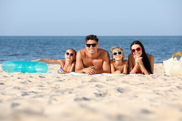 Happy family on sandy beach near sea. Summer holidays
