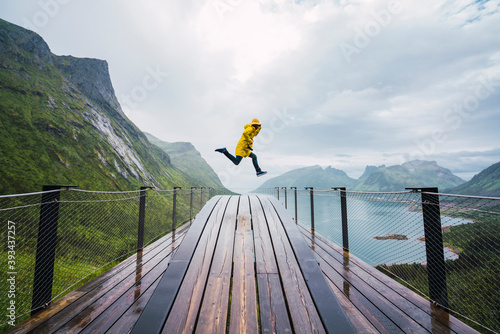 Norway, Senja island, man jumping on an observation deck at the coast photo