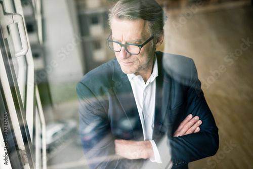 Serious mature businessman looking out of window