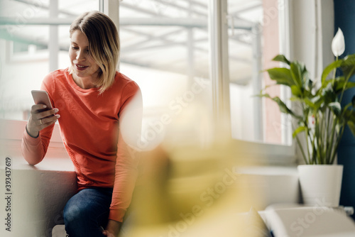 Woman using smartphone at home photo