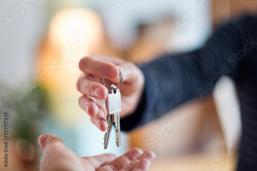 Close-up of hand over of house key in new home