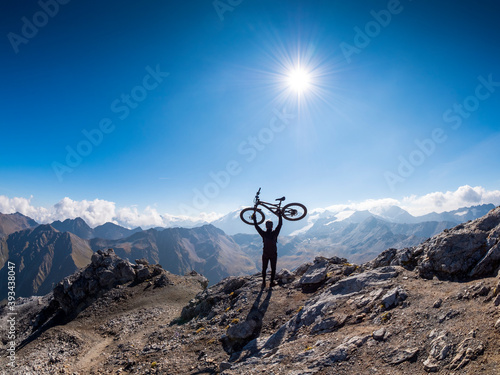 Border region Italy Switzerland, cheering man with mountainbike on peak of Piz Umbrail photo