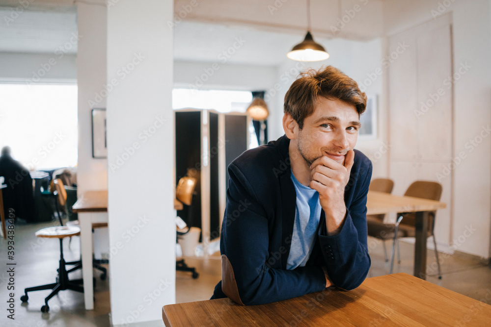 © Kniel Synnatzschke/Westend61 - Portrait of smiling man sitting at table