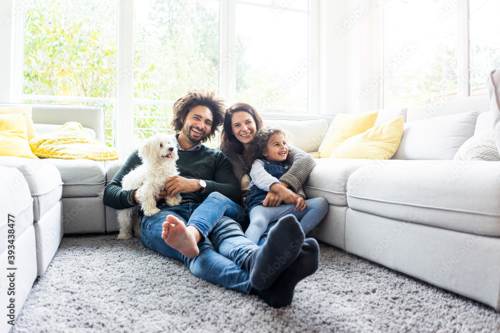 Happy family with dog sitting together in cozy living room Happy family with dog sitting together in cozy living room