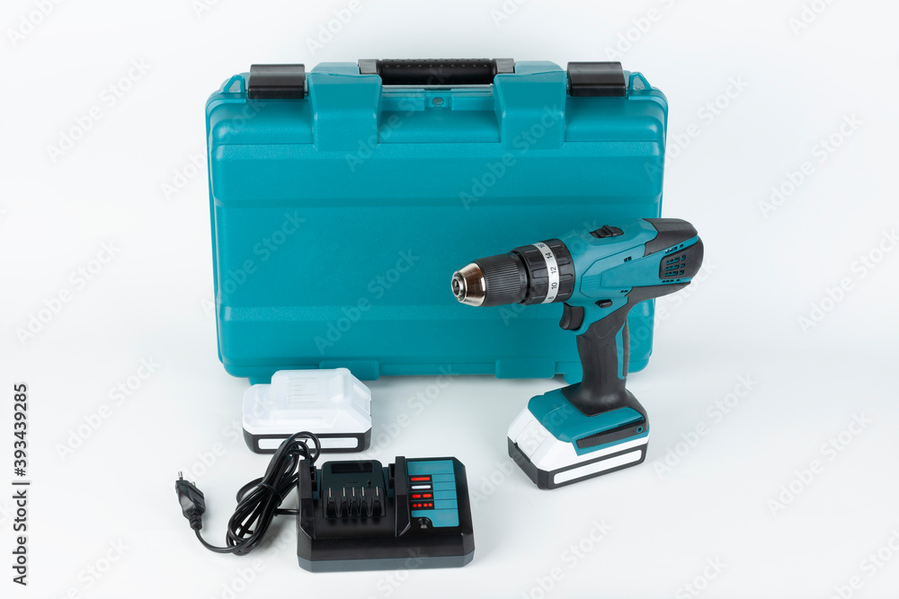 Cordless hammer screwdriver drill, battery charger and second battery and carry case on white background. Studio shoot. Cordless hammer screwdriver drill, battery charger and second battery and carry case on white background. Studio shoot.