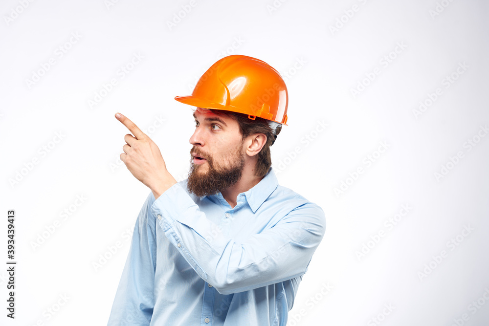 Man in orange hard hat industry engineer work professional light background