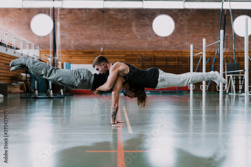 Two men doing acrobatics in gym