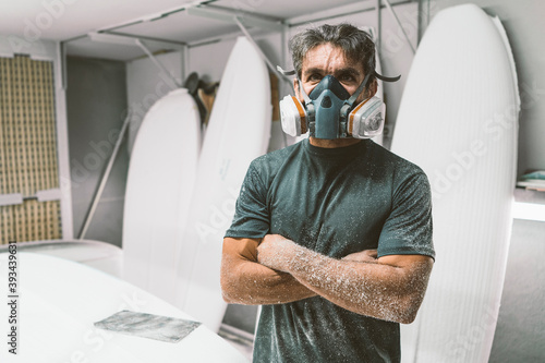 Mature man with arms crossed wearing protective face mask standing indoors photo