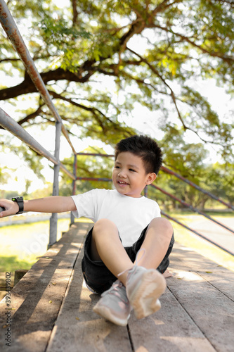 Portrait of a happy little asian boy in the park. Kid having fun in spring park.