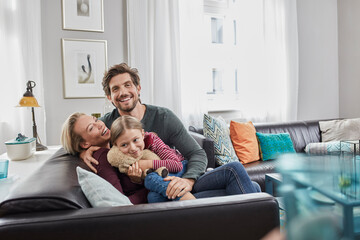 Portrait of happy family sitting on couch at home