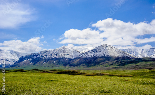 Snow line on mountains ending at prairie grass. © ArchonCodex
