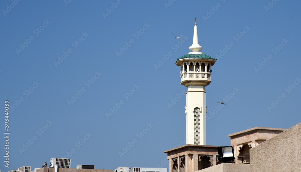 Minarett der Bastakiya-Moschee im historischen Al-Fahidi-Viertel vor strahlend blauem Himmel Minarett der Bastakiya-Moschee im historischen Al-Fahidi-Viertel vor strahlend blauem Himmel