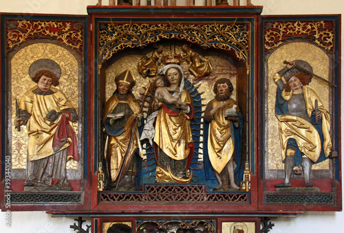Madonna con Bambino tra San Mauro e San Giovanni Battista; ai lati, Santo Stefano e San Michele; altare scolpito nella chiesa di San Mauro presso Baselga di Pinè