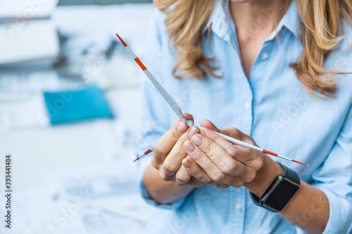 Close-up of woman in office holding wind turbine model photo