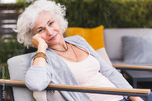 Thoughtful mature woman sitting at home photo