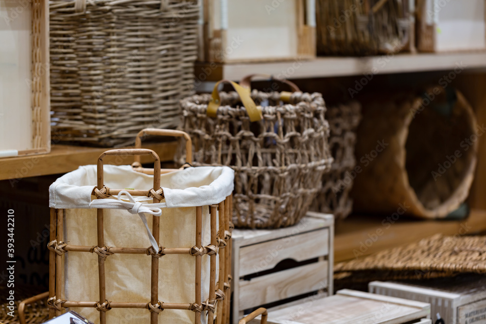 Woven straw baskets, container and boxes on a shelf in store. Bamboo weaving basket and brown Linen on shelf of rack background. Household decoration objects made of natural eco materials. Woven straw baskets, container and boxes on a shelf in store. Bamboo weaving basket and brown Linen on shelf of rack background. Household decoration objects made of natural eco materials.