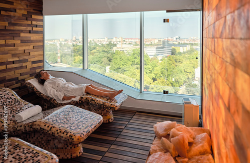 Senior woman relaxing while lying on lounge chair at health spa