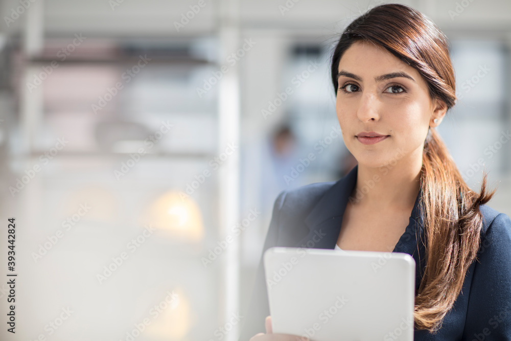 Portrait of young businesswoman with tablet in office Portrait of young businesswoman with tablet in office