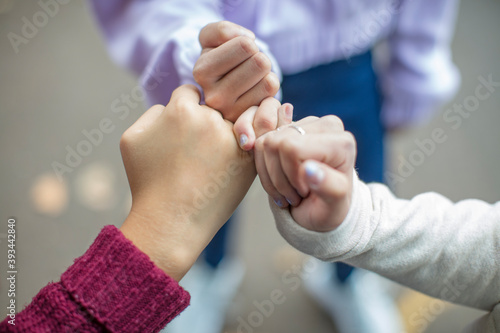 Close-up of teenage girls making a pinky promise