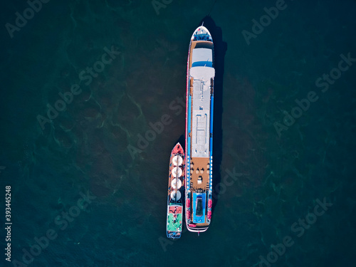 Barge refueling recreational boat on Volga River photo