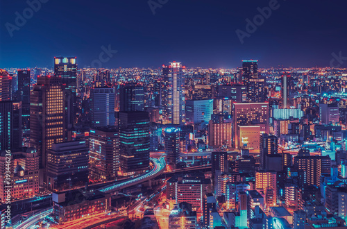 Illuminated modern buildings in city at night, Osaka