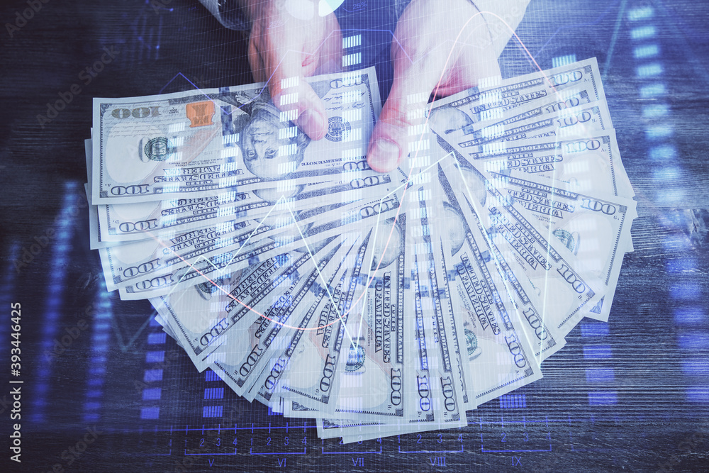 Multi exposure of financial graph drawing hologram and USA dollars bills and man hands. Analysis concept. Multi exposure of financial graph drawing hologram and USA dollars bills and man hands. Analysis concept.