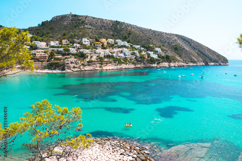 Summer at beautiful El Portet Beach with crystal clear turqouise waters in Moraira, Costa Blanca, Spain photo