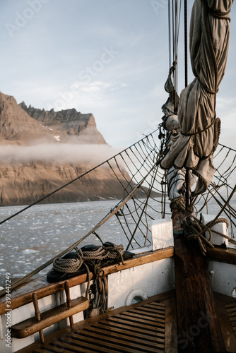 Fototapeta View on the rocky greenland coast from the wooden vintage sailboat