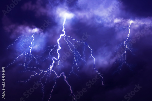 Fototapeta Lightnings in dark cloudy sky during thunderstorm
