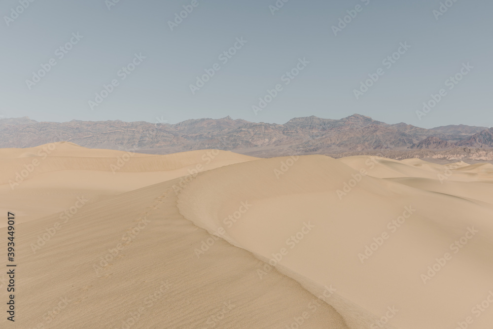 sand dunes with mountains in the background sand dunes with mountains in the background