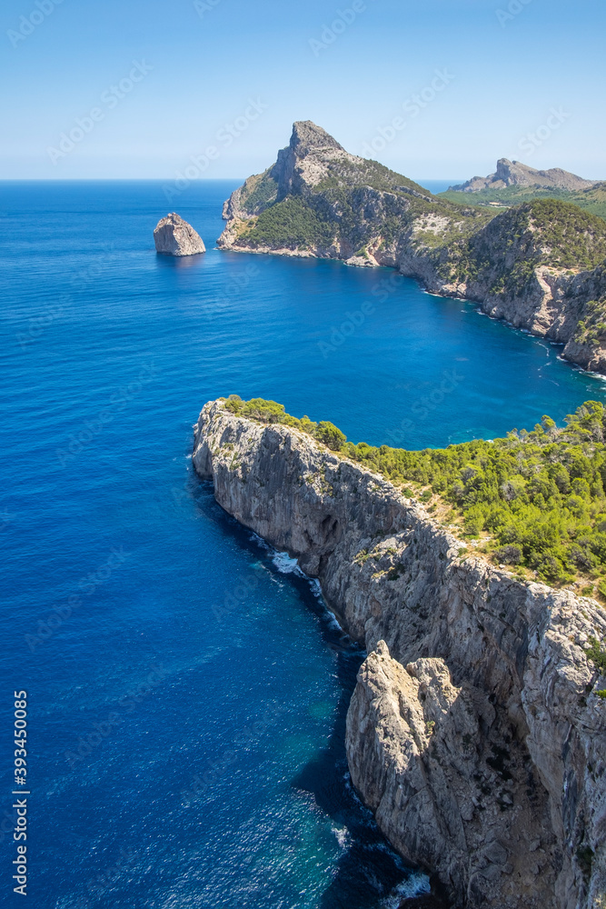 View of a rocky cliff on a sunny day in Formentor cape in Palma de Mallorca, Balearic Islands, Spain, verical