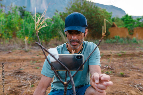 Male traveler installing smartphone on improvised tripod photo