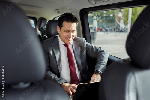 Businessman working on his laptop in a car