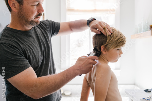 Little boy getting hair trimmed at home photo