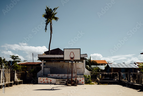 Shabby basketball court in the street on sunny day photo
