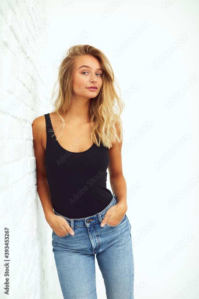 Young woman leaning against a brick wall Young woman leaning against a brick wall