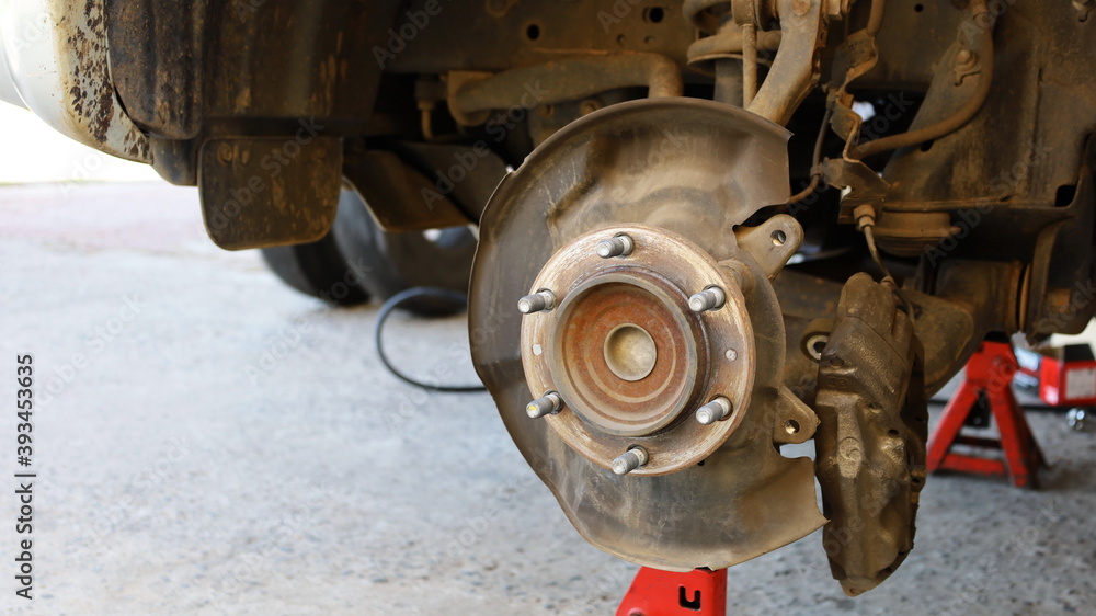 Hubs and wheel screws. Replace the front wheels of the car or perform maintenance on a stand on the background of cement with copy space. Close focus and select an object Hubs and wheel screws. Replace the front wheels of the car or perform maintenance on a stand on the background of cement with copy space. Close focus and select an object