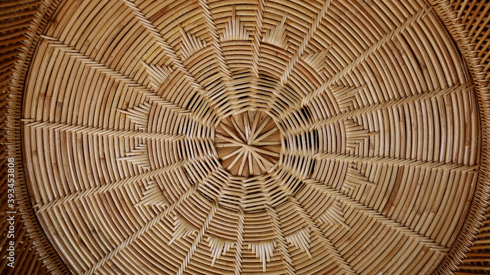 Rattan weave circular pattern. Hand-woven local crafts are beautifully woven rattan furniture. Full frame brown textured background. Close focus and select an object
