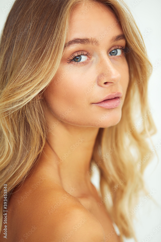 Young woman glancing over her bare shoulder Young woman glancing over her bare shoulder