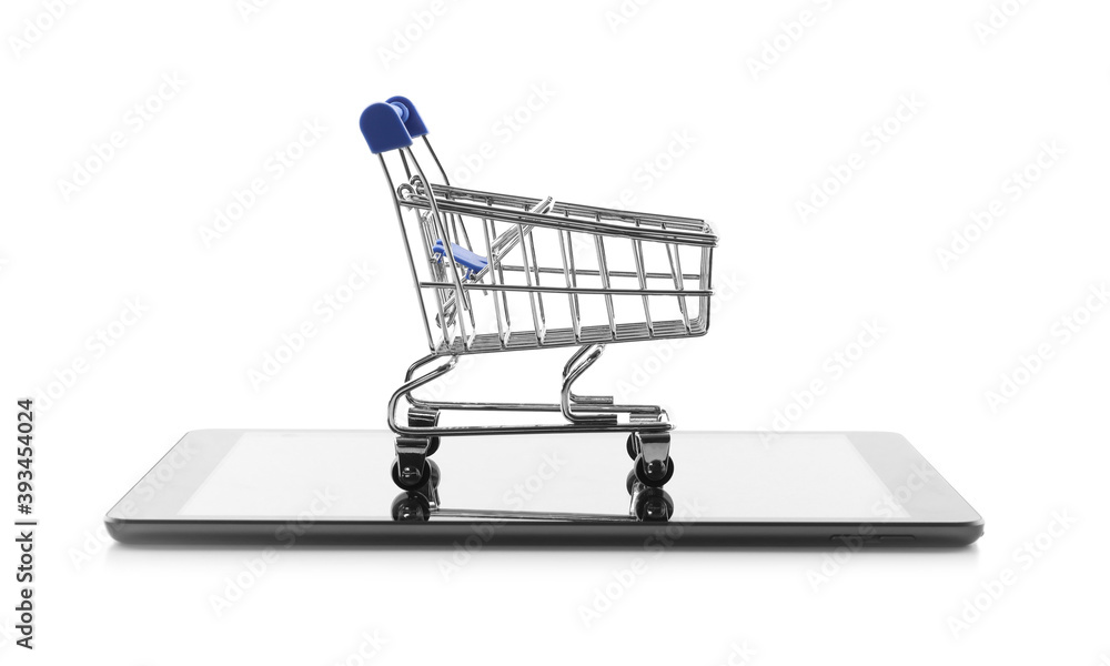 Internet shopping. Small cart and modern tablet on white background