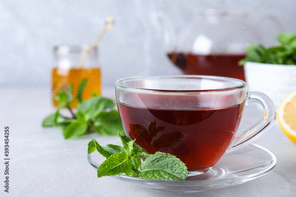 Fresh tea with mint on light table Fresh tea with mint on light table