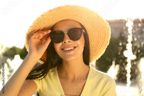 Beautiful young woman wearing stylish sunglasses outdoors