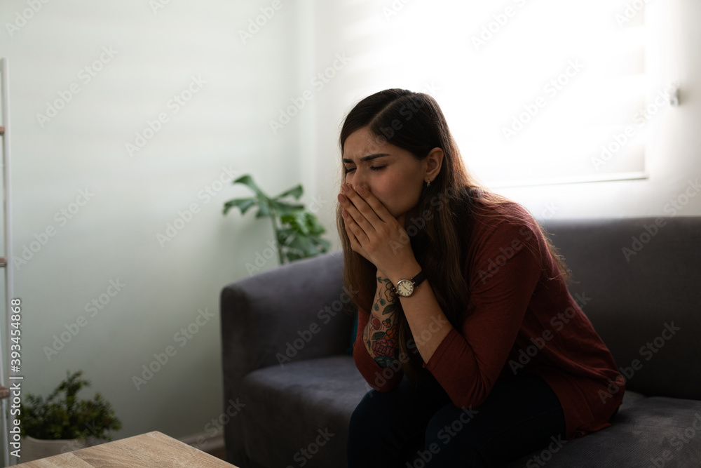 Anxious woman in his 20s sitting on her living room Anxious woman in his 20s sitting on her living room