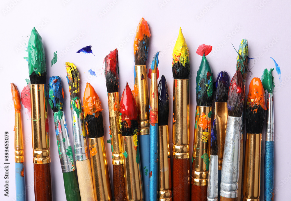 Brushes with colorful paints on white background, flat lay Brushes with colorful paints on white background, flat lay