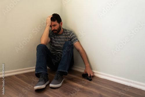 Hopeless man with suicidal thoughts holding a pistol