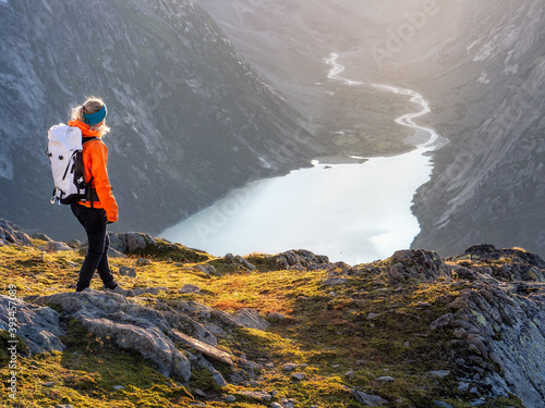 Hiking girl looking towards glacier valley and lake photo